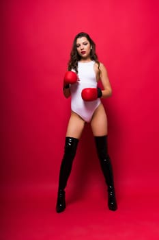 Attractive young brunette woman in a boxers gloves, studio shot