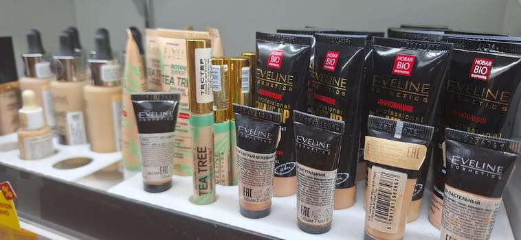Bobruisk, Belarus - May 1, 2024: Various makeup products Eveline cosmetics, including foundations and concealers by Eveline and other brands, are neatly arranged on a store shelf.
