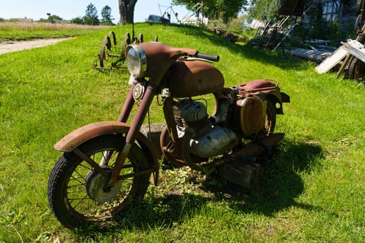Kretinga, Lithuania - August 12, 2023: An aged motorcycle Jawa stands parked in a field of green grass, showcasing its vintage charm against the natural backdrop.