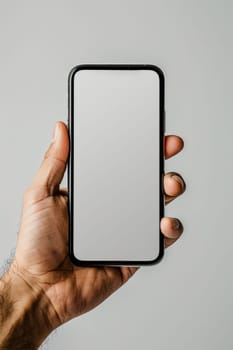 A person is holding a phone with a white screen. The phone is a new model and he is a high-end device