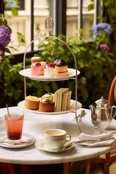 Afternoon tea in the restaurant garden, English tradition and luxury service, tea cups, cakes, scones, sanwiches and desserts, holiday table decor and afternoon tea stand, post-processed, generative ai