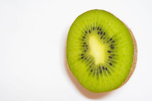 Close up from a kiwi cut in half on a white background.