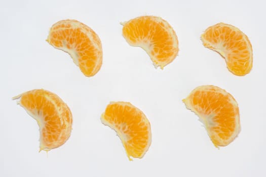 Flatlay of some peaces of tangerine on a white  background.