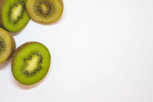 Mix of green and yellow kiwi's cut in half, on a white background.