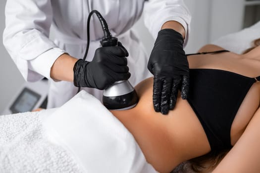 Following ultrasound cavitation of the abdomen of woman, the vacuum procedure is implemented to enhance results.