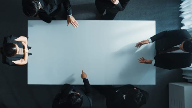 Top down aerial view of smart cooperate businessman discussing about marketing strategy. Diverse business group brainstorming idea startup project and financial plan at meeting room. Directorate.