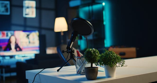 Empty home studio interior with professional recording devices used for internet show production. Apartment filled with content creation equipment, TV running in background, close up