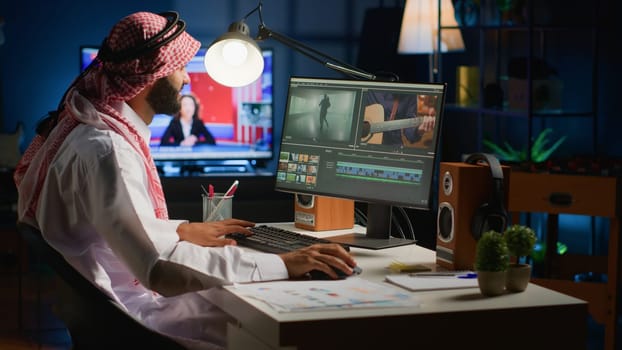 Arabic cinematographer in home office editing project using filmmaking techniques, working with footage and sound. Middle Eastern man using videography software to process movie on workstation