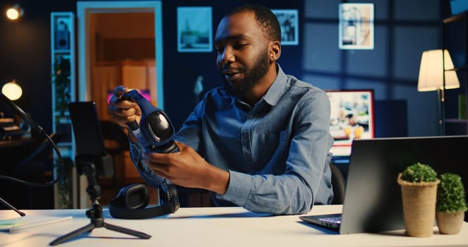 Tech influencer filming review of noise cancelling headphones comparison between two pairs, giving feedback on best performing one, recording video with professional equipment