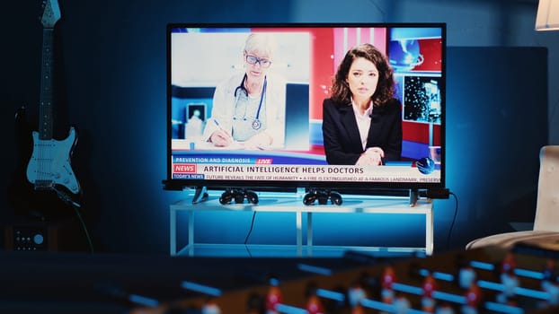 Close up shot of TV left open at night in cozy dimly lit apartment showing broadcast of news story. Home entertainment system showing television reports in living room, panning shot