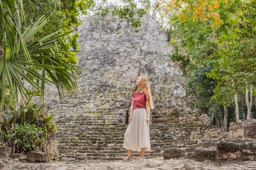 Woman tourist at Coba, Mexico. Ancient mayan city in Mexico. Coba is an archaeological area and a famous landmark of Yucatan Peninsula. Cloudy sky over a pyramid in Mexico.