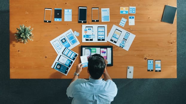 Top view of skilled developer walking and placing Ux Ui software. Smart business man put tablet on meeting table with mobile phone interface or icon. Investor plan develop software plan. Convocation.
