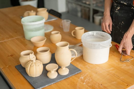 Close-up of a potter's hands glazing a ceramic mug