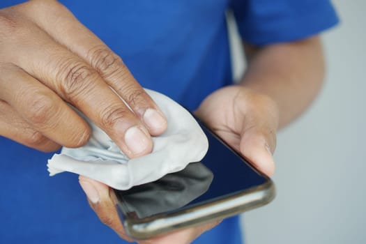 man hand cleaning mobile phone display