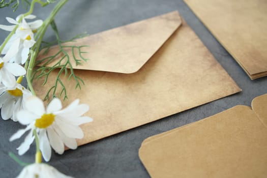 envelope , empty paper and a flower on table .