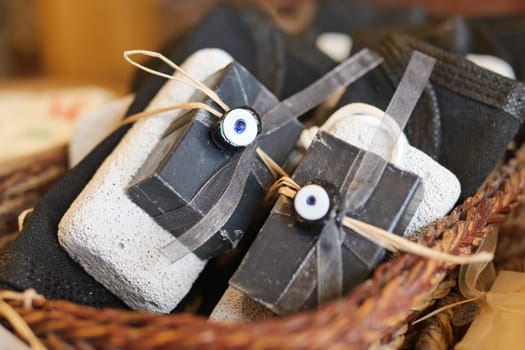 A stack of black soaps with a ribbons in a basket,