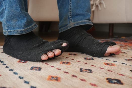 men feet with dirty socks while sitting on sofa .