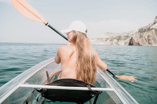 Woman in kayak back view. Happy young woman with long hair floating in transparent kayak on the crystal clear sea. Summer holiday vacation and cheerful female people having fun on the boat.