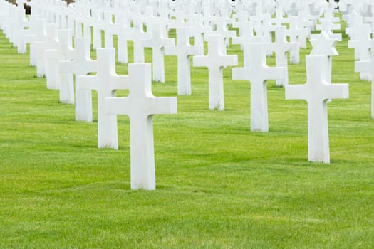 American cemetery at Normandy area. WWII memorial. Lines of bright white grave stones on green grass. High quality photo