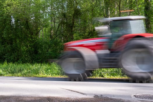 Motion blur of fast red tractor. concept of fast agriculture and dangers of speed to consumer and agibusiness. High quality photo