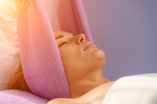 Relaxing massage. European woman getting head massage in spa salon, side view.