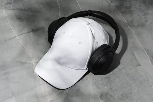 Baseball cap with black headphones on dark background studio shot