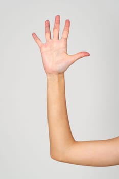 Womans Hand With Blue Nail Polish on gray background close up