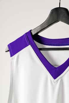 White basketball jersey hanging against white background close up