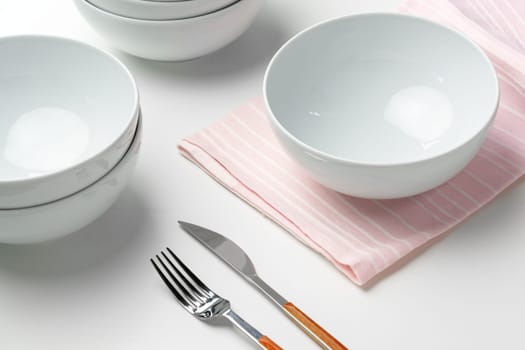 Stylish table setting with white dishware on white tablecloth close up