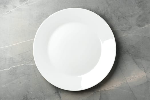 White empty plate on gray background top view close up