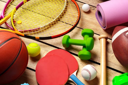 Different sports equipment on wooden background top view photo