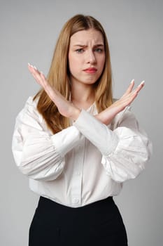 oung Woman Making X Sign With Arms to Express Prohibition or Disagreement in studio