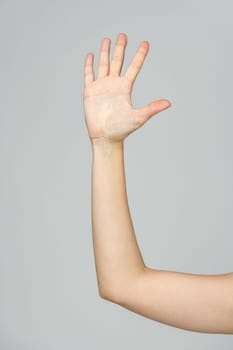 Young Woman Arm with Gesture close up on gray background