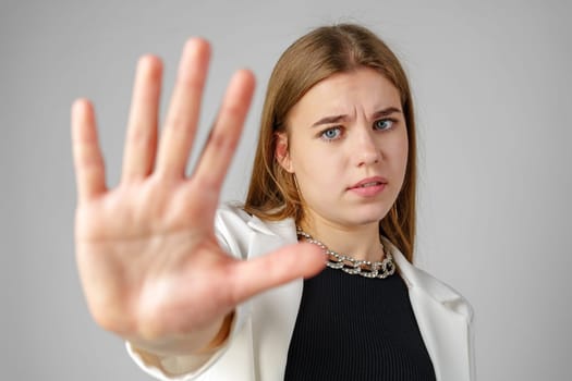 Young Woman Making Stop Sign With Hand in Studio