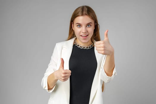 Confident Young Woman in Business Attire Giving Ok Sign in Studio Setting close up