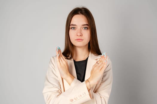 Young Woman Standing With Arms Crossed on gray background in studio