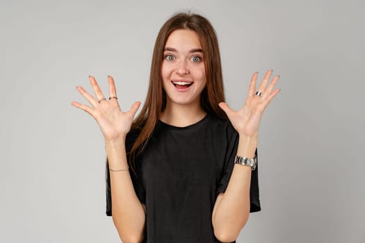 Young Woman Showing Surprise Expression on Gray Background close up