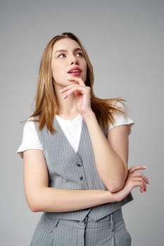 Concerned Young Woman deep in thought or contemplation on gray background