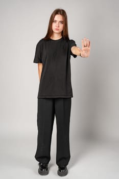 Young Woman Gesturing Stop With Her Hand in a Studio Setting