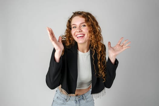 Young Curly Clueless Woman Holding Out Hands in studio