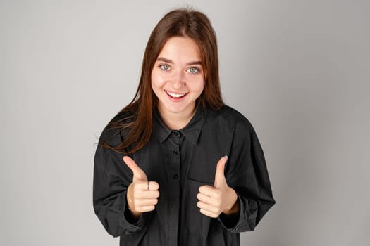 Young Woman Making OK Sign With Fingers in Studio