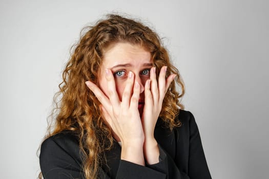 Young Woman Covering Face With Hands in Studio close up
