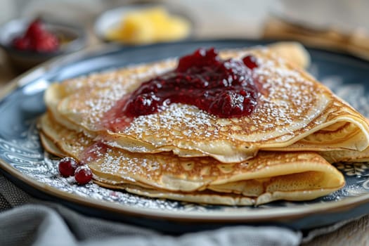 A stack of pancakes with lingonberry sauce on a plate on a wooden table. Swedish cuisine dish.