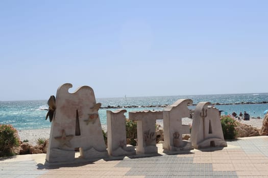 Stone block of the seafront promenade with the name of a Spanish coastal town. In the letters it says in Spanish Altea . Alicante. Spain