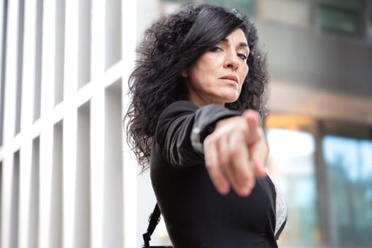 Caucasian woman feeling angry, disgusted, upset, showing her finger towards the camera.