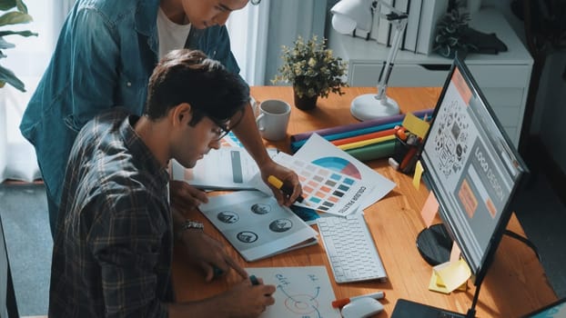 Top view of project manager looking at screen while designer writing idea. Close up of smart business team explain idea of logo design while designer choose theme while looking at palette. Symposium.