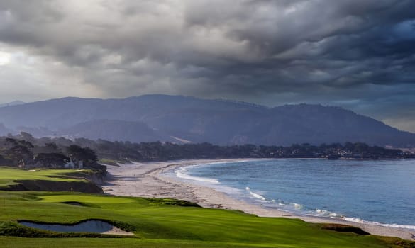 oceanside golf course with bunker,  ocean and clouds