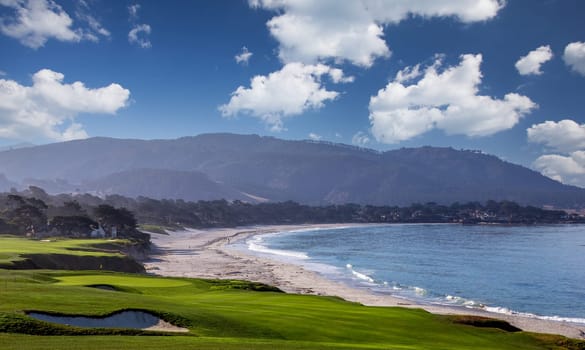 oceanside golf course with bunker,  ocean and clouds