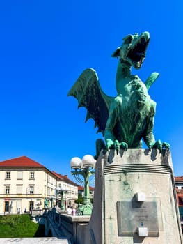 View of the Dragon bridge (Zmajski most), symbol of Ljubljana, capital of Slovenia, Europe. Sculpture of a dragon against a blue sky.