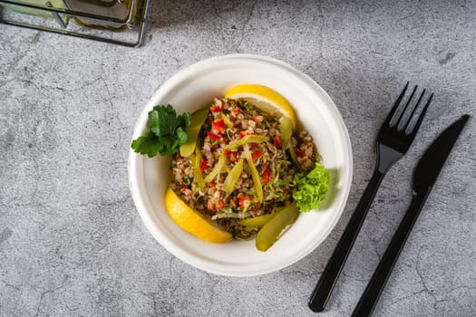 Quinoa salad on a white styrofoam plate on a stone table